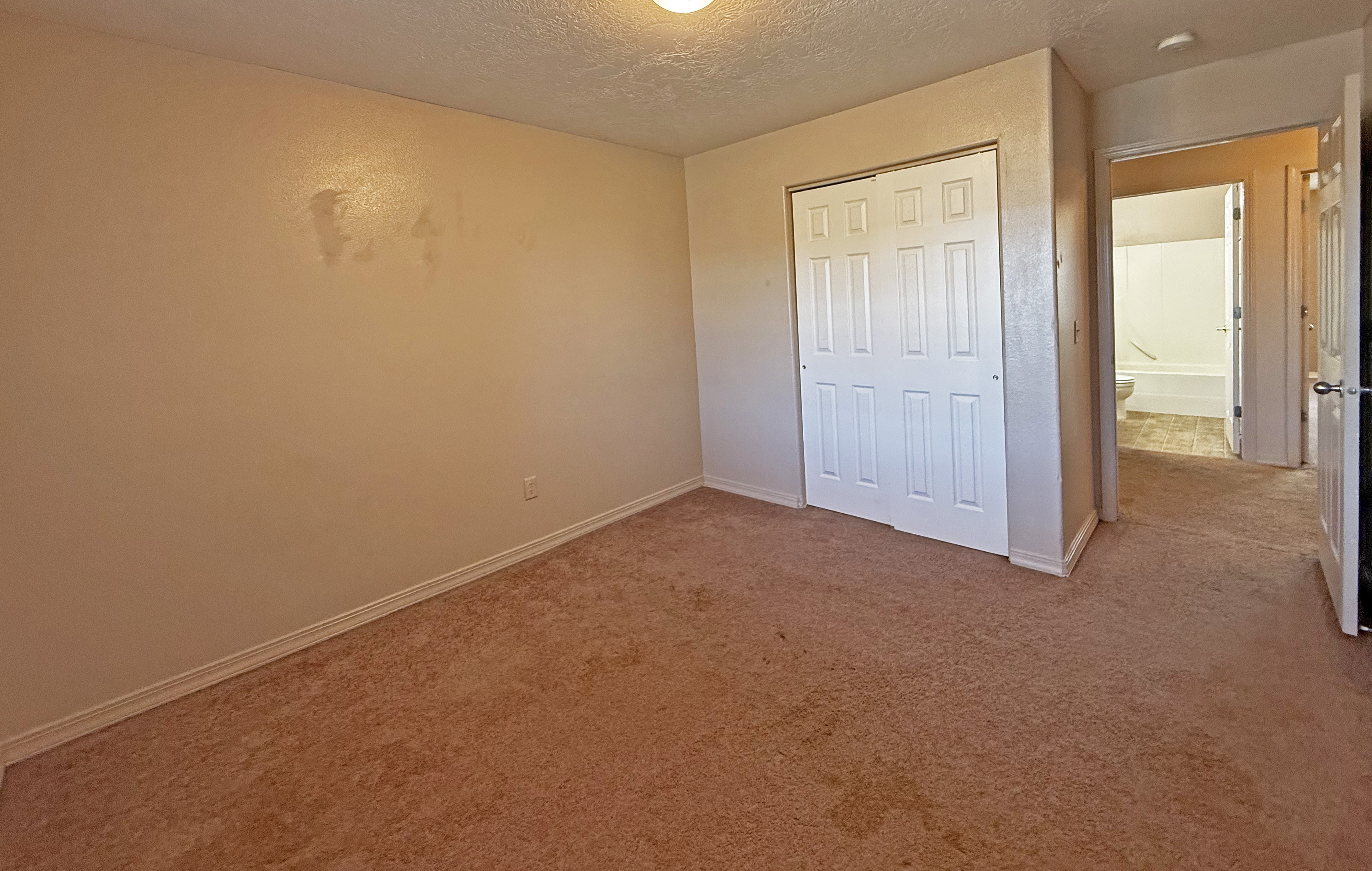 Third bedroom with open door overlooking hallway and second bathroom